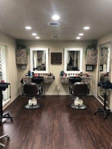 - Results Salon and Spa in Kingsport, TN Two salon stations with mirrors, chairs, and styling tools are set up in a room with wood flooring and overhead lighting. - Results Salon and Spa in Kingsport, TN
