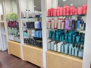 - Results Salon and Spa in Kingsport, TN Shelves displaying a variety of hair care products in colorful bottles, organized by brand and type in a well-lit store. - Results Salon and Spa in Kingsport, TN