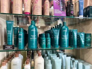 - Results Salon and Spa in Kingsport, TN Shelves display various Aveda hair care products, including Botanical Repair and Cherry Almond lines, arranged in rows by type and size. - Results Salon and Spa in Kingsport, TN