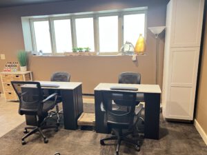 - Results Salon and Spa in Kingsport, TN Two black office chairs face two desks in front of a window, with potted plants on the windowsill and storage furniture along the walls. - Results Salon and Spa in Kingsport, TN
