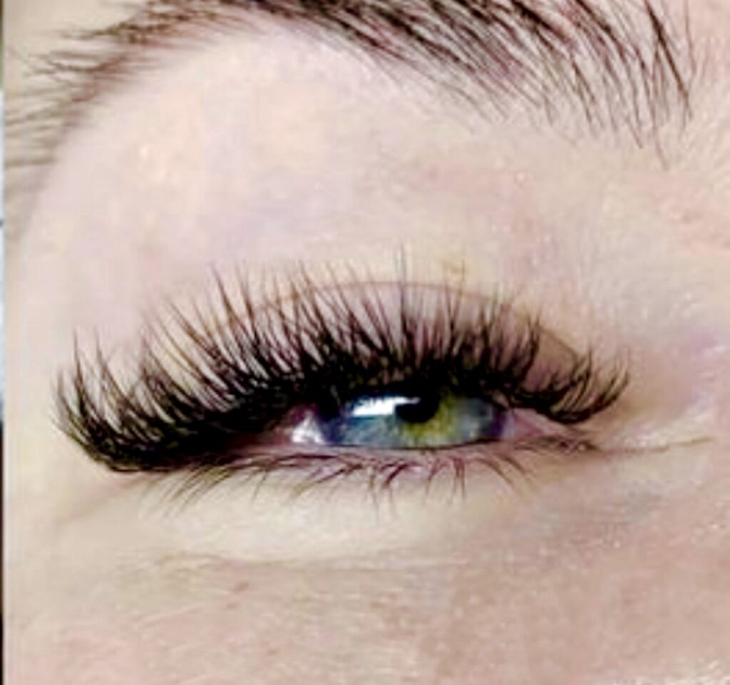 - Results Salon and Spa in Kingsport, TN Close-up of a person's eye with long, thick, curled eyelash extensions and light-colored skin. The eye appears blue-green in color. - Results Salon and Spa in Kingsport, TN